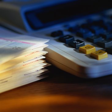 Stack of bills beside calculator