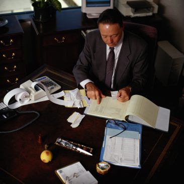 Businessman Going Over Receipts in His Office